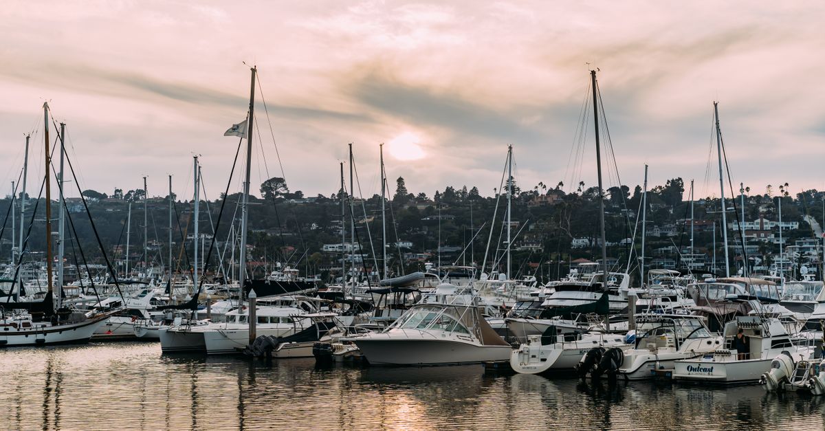 A picturesque marina filled with sailboats at sunset, showcasing serene waters and a calming atmosphere.
