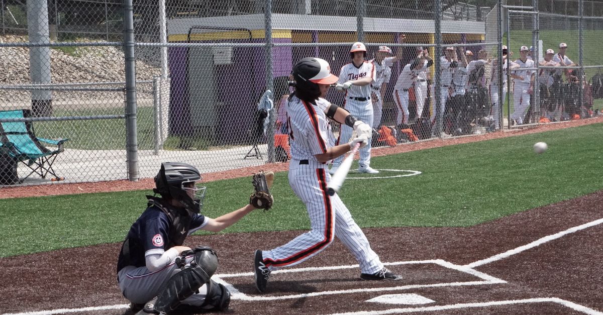 A thrilling moment on the baseball field capturing the batter hitting the ball, with players in the background.
